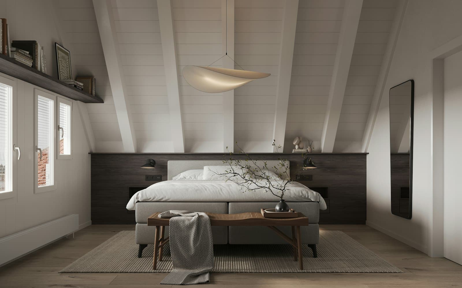 Suite amplia bajo vigas pintadas de blanco, con una cama baja, un banco y tres ventanas pequeñas