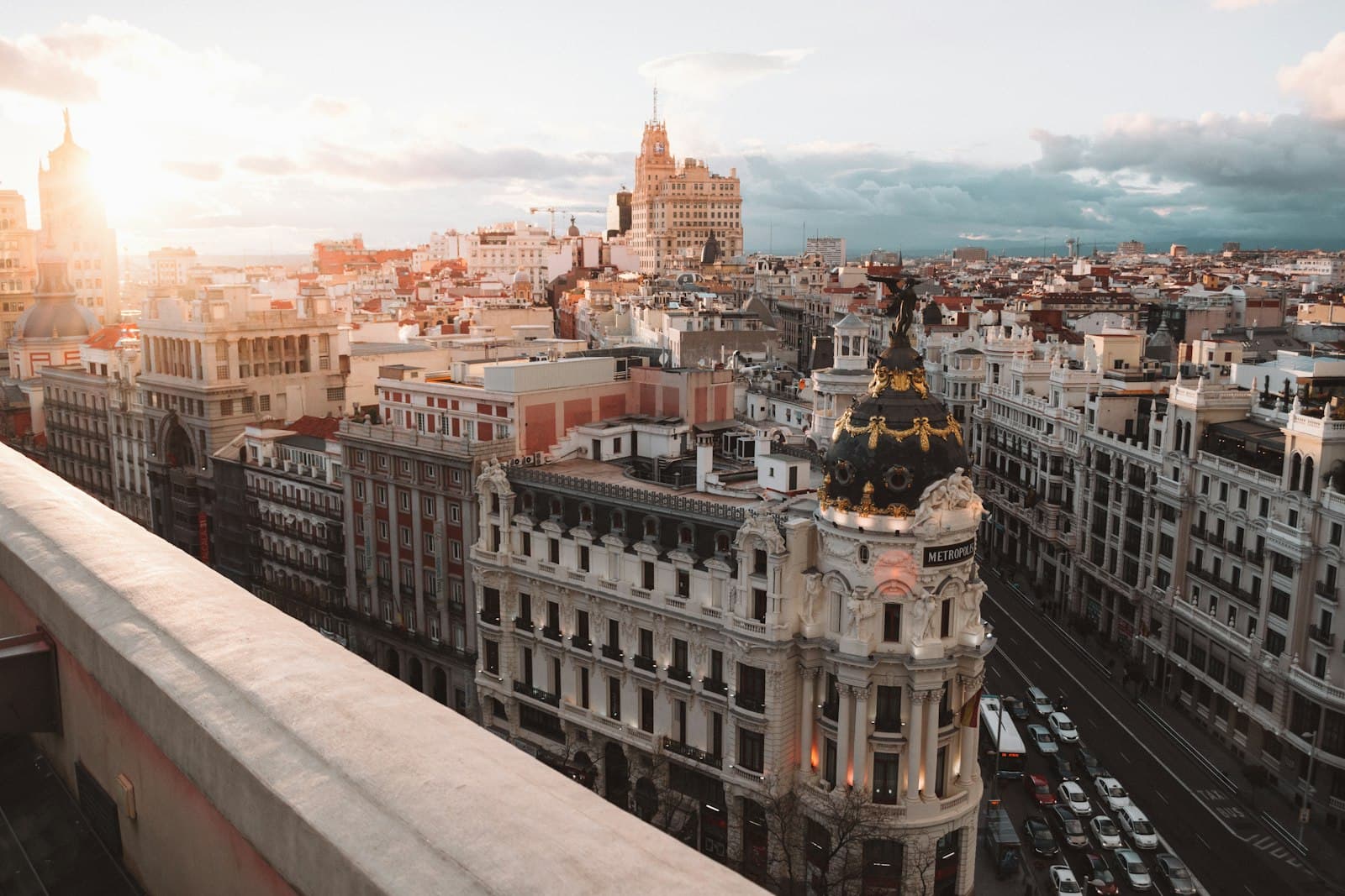 Vista desde el antepecho de la azotea sobre las cúpulas y los tejados del centro de Madrid, con una luz dorada y baja