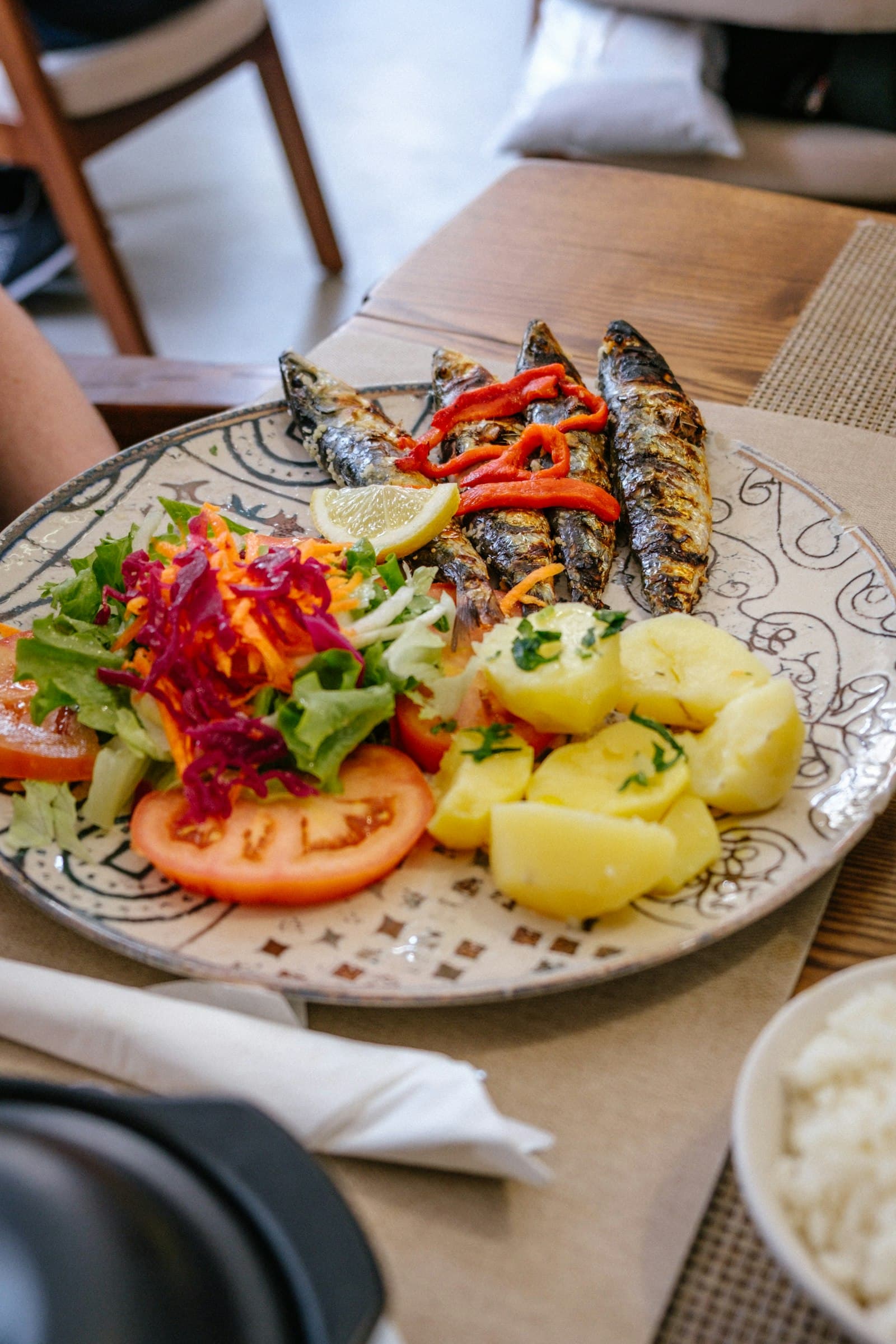 Plato de sardinas a la brasa con papas cocidas y ensalada fresca